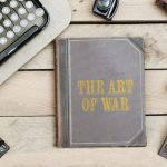 Sun Tzu's Art of War book on a desk with old other old items