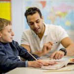 Teaching assistant supporting a child with SEND in school